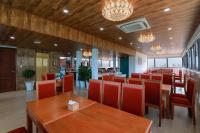 Un restaurante con mesas de madera y sillas rojas. en Maya Hotel 4, en Con Dao