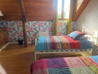 two beds in a bedroom with floral wallpaper at Loire Valley Llama Farm Stay in Lavernat