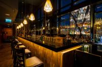 a bar with a long counter with bar stools at Warsaw Presidential Hotel in Warsaw