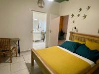 ein Schlafzimmer mit einem Bett mit Vögeln an der Wand in der Unterkunft Myosotis, charmant logement central avec piscine privée, wifi et parking gratuit in Petit-Bourg