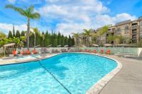 a large swimming pool with chairs and palm trees at Hilton Irvine/Orange County Airport in Irvine