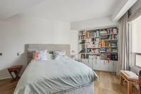 a bedroom with a large bed and bookshelves at Quai des Célestins 2bdr in Paris