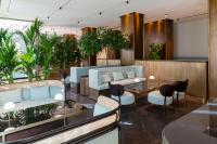 a waiting room with blue chairs and plants at Radisson Collection Hotel, Roma Antica in Rome
