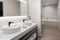 a white bathroom with two sinks and a tub at San Juan Marriott Resort and Stellaris Casino in San Juan