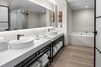 a white bathroom with two sinks and a tub at San Juan Marriott Resort and Stellaris Casino in San Juan