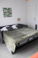 a bedroom with a large bed with a green comforter at City Lodge Appart Hôtel Niort in Niort