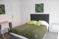 a bedroom with a large bed with two green pillows at City Lodge Appart Hôtel Niort in Niort