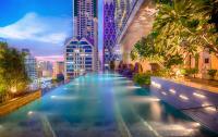 a pool in the middle of a city at night at Eastin Grand Hotel Sathorn in Bangkok