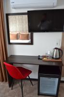 escritorio con silla roja y TV en la pared en HOTEL GLOBAL 2022, en Estambul