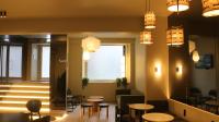 a waiting room with tables and chairs and lights at Gspot Hostels & Love Triangles Pizzeria in Lisbon