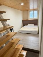 a small room with a bed and wooden tables at Star-Moon B&amp;B Green Island in Green Island