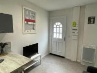 a living room with a door and a tv at APPARTEMENT HYPER CENTRE numéro 101 in Roanne