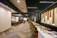 a dining room with wooden tables and chairs at Hotel Pavitra in Pūrnia