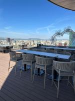 Un patio con una mesa y sillas en un tejado. en Sky Hotel Tirana, en Tirana