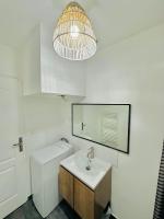 a white bathroom with a sink and a mirror at BtoBed - Studios Paris Le Bourget in Le Bourget