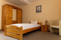 a bedroom with a wooden bed and a chair at Hotel Anker in Saalfeld