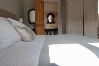 a bedroom with a white bed with a light on it at Kermaria Studio Suite in Pont-Aven