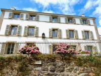 a large white building with flowers on a fence at Kermaria Studio Suite in Pont-Aven