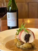 Un plato blanco con un sándwich y una botella de vino. en The Kings Arms Temple Sowerby, en Temple Sowerby