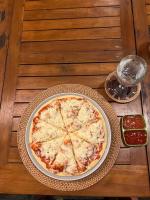 LabuhanpohにあるLombok Villas, Villa KuraKuraの木のテーブルの上に置いたピザ