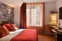 Un dormitorio con una cama y un escritorio y una ventana. en Logis Hôtels Le Saint Georges, en Vendôme