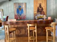 a wooden bar with chairs and paintings on the wall at Mas de la pie in Saintes-Maries-de-la-Mer