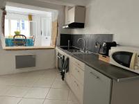 a kitchen with a sink and a microwave at Maison de village in Lédenon