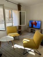 a living room with two chairs and a flat screen tv at Maison de village in Lédenon