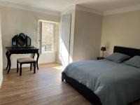 a bedroom with a bed and a table and a piano at Maison de village in Lédenon