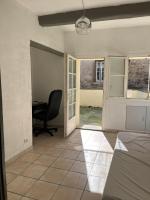 a bedroom with a desk and a chair in a room at Maison de village in Lédenon