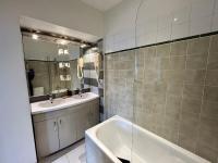 a bathroom with two sinks and a tub and a mirror at Le Richelieu Bacchus in Fontainebleau