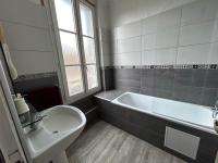 a bathroom with a tub and a sink and a toilet at Le Richelieu Bacchus in Fontainebleau