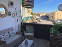 a balcony with a couch and a view of a street at Tropical Duplex : Bord de mer + Piscine in Frontignan