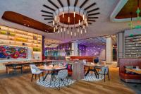 Un restaurante con mesas y sillas y una lámpara de araña. en Moxy Putrajaya, en Putrajaya