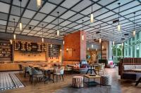 Un restaurante con mesas y sillas y un bar. en Moxy Putrajaya, en Putrajaya