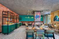 Un restaurante con mesas y sillas en una sala. en Moxy Putrajaya, en Putrajaya