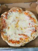 eine Käsepizza in einer Schachtel in der Unterkunft Aux Chambres du Mont in Huisnes-sur-Mer