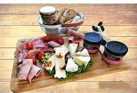 ein Teller mit Fleisch und Käse auf einem Schneidebrett in der Unterkunft Aux Chambres du Mont in Huisnes-sur-Mer