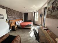 a bedroom with a bed and a brick wall at Le Richelieu Bacchus in Fontainebleau