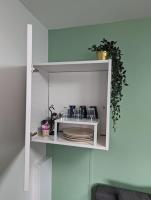 a white shelf with plates and a plant on it at La Madeleine d&#39;Eybens (Grenoble) in Eybens