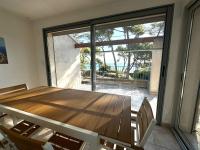 ein Esszimmer mit einem Holztisch und einem großen Fenster in der Unterkunft Grande villa face à la plage, superbe vue mer in La Seyne-sur-Mer