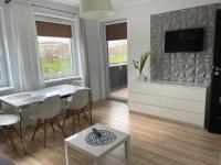 Televízia a/alebo spoločenská miestnosť v ubytovaní Apartament Ogrody