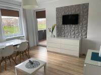 Televízia a/alebo spoločenská miestnosť v ubytovaní Apartament Ogrody