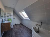 a bathroom with a sink and a tub and a window at Chambre en centre ville proche mer in Saint-Pol-de-Léon