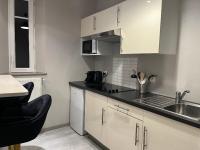 a small kitchen with white cabinets and a sink at Le Charme D&#39;Antan in Évreux