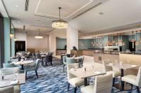 Un restaurante con mesas y sillas y un bar. en Hilton London Gatwick Airport, en Horley