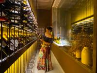 una mujer parada en una tienda mirando un estante de jarrones en Alua Camburi, en Camburi