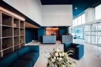 a lobby with a blue couch and two chairs at Hotel Lille Euralille - Hilton Affiliate Hotel in Lille
