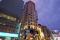 a tall building with a clock on it in a city at Kung Shang Design Hotel in Kaohsiung