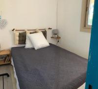 a bedroom with a large bed with a pillow on it at Sur la Presqu&#39;île des Dosses in Le Barcarès